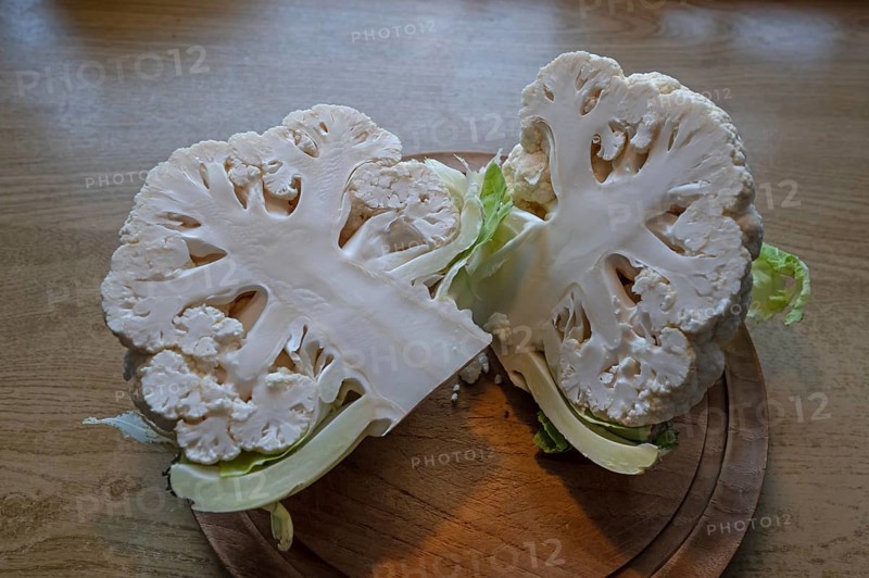 Halved cauliflower (Brassica oleracea var. botrytis) on a wooden board, Bavaria, Germany