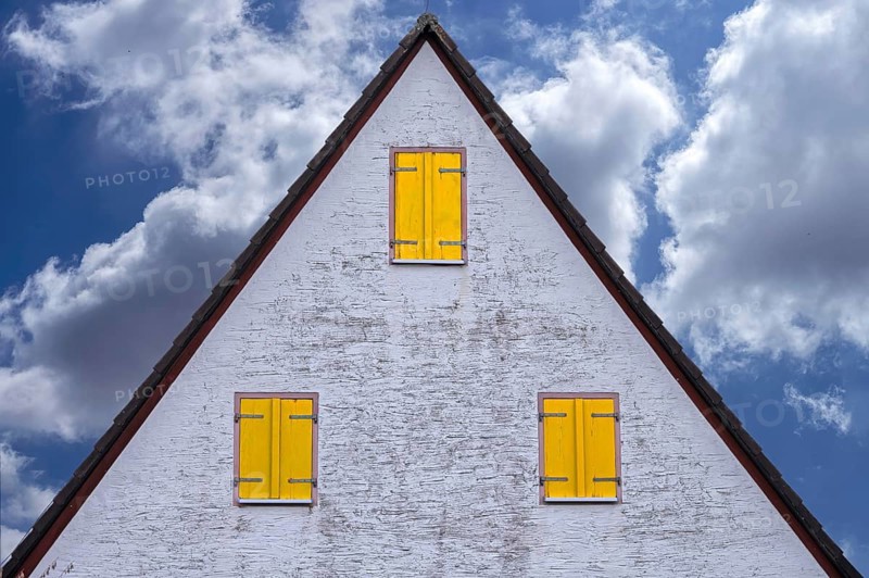 Old gable of a farmhouse with yellow shutters, cloudy sky, Beerbach, Middle Franconia, Bavaria, Germany