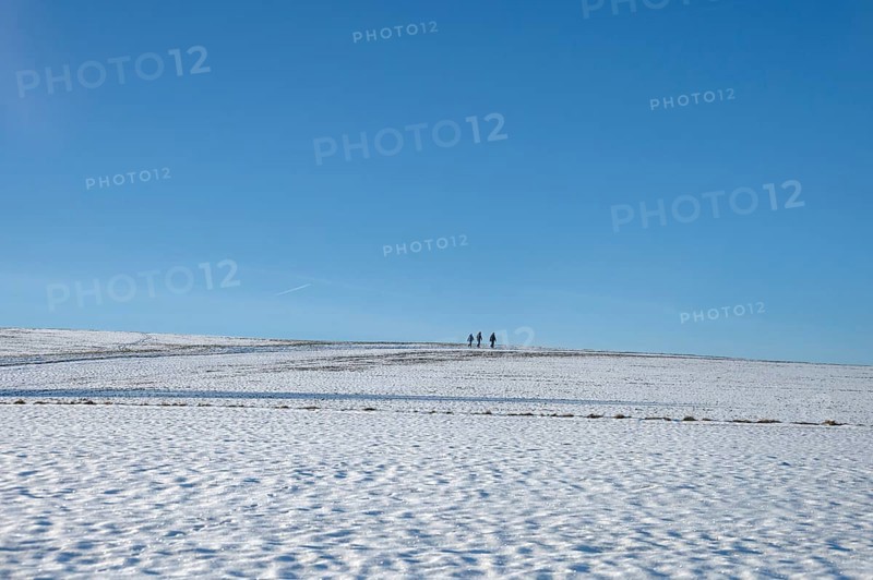 Snowy landscape with three hikers, blue sky, Beerbach, Middle Franconia, Bavaria, Germany