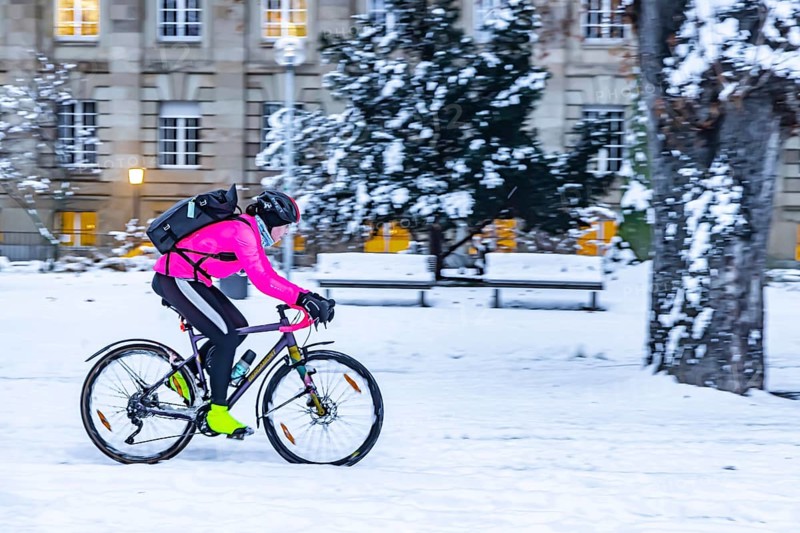 Winter in Stuttgart. It snowed overnight and the city is wintry white early in the morning. Cyclists in the snow in the Lower Palace Garden. Stuttgart, Baden-Württemberg, Germany