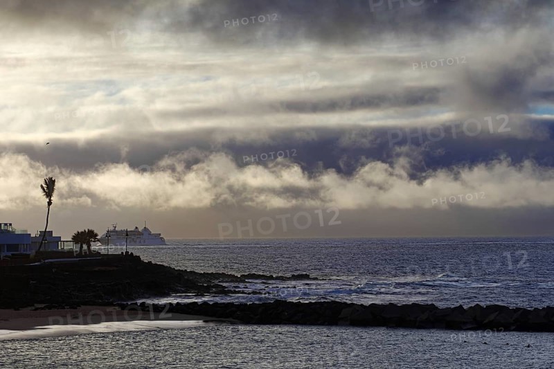 Dramatic scenery with clouds over the sea and a distant ship, Playa Blanca Lanzarote