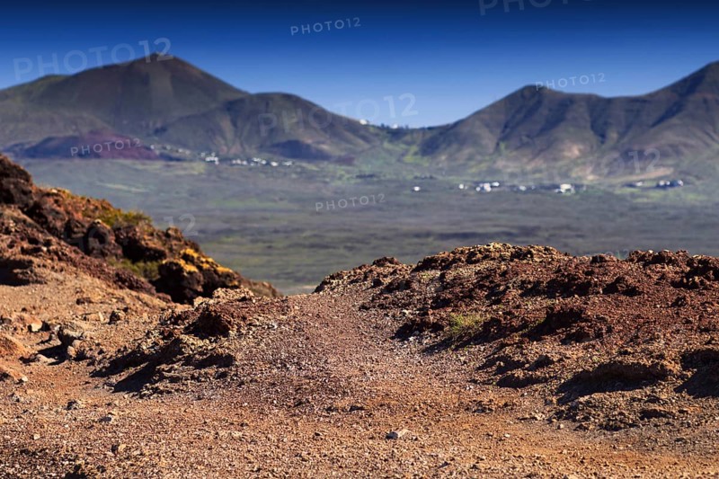 Volcanic landscape with mountains and eroded soil under blue sky, Playa Blanca Lanzarote