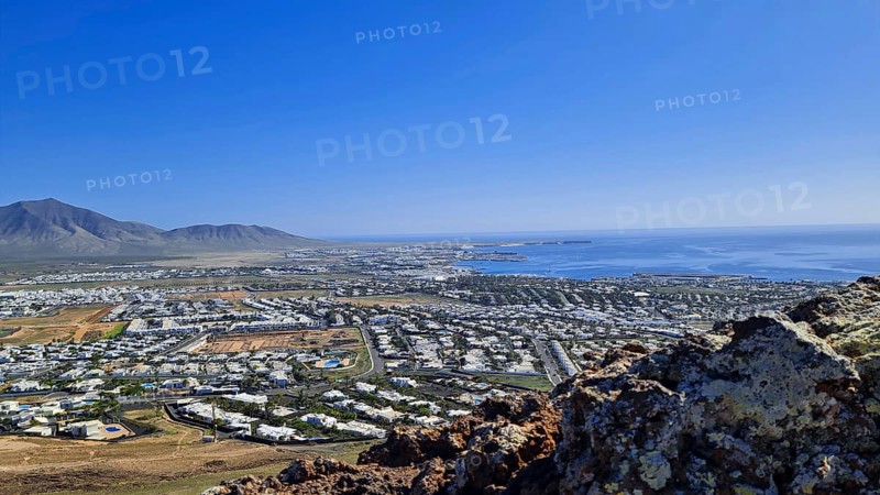 Panorama of the coastal town (Playa Blanca) with sea view and mountains under a clear sky, Playa Blanca Lanzarote