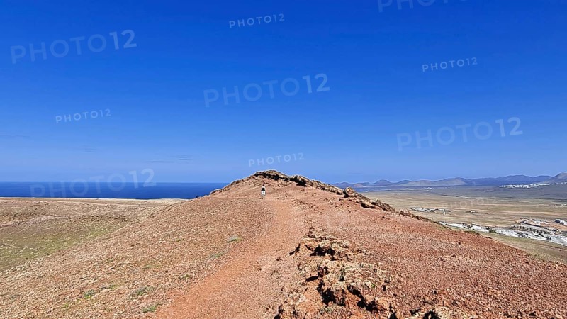 Narrow path on the summit of the Montana Roja volcano with views of the sea under a clear blue sky, Playa Blanca Lanzarote