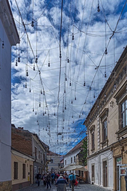 Light bulbs between houses for evening lighting, Cluj-Napoca, Transylvania, Romania