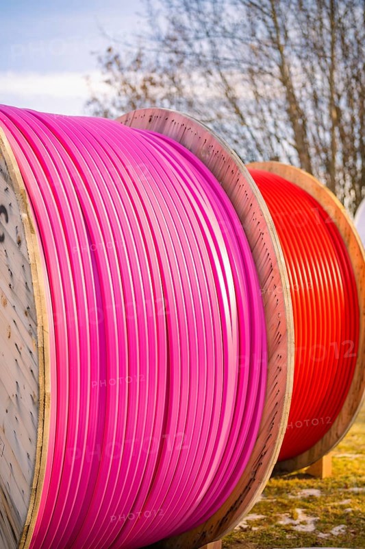 Large, coloured cable drums with pink and red cables outdoors, fibreglass groundbreaking, Freudenstadt, Germany