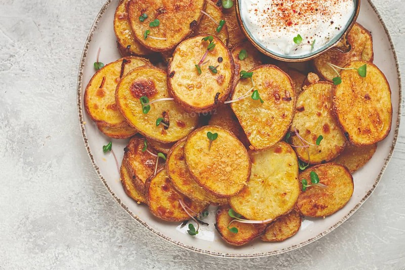 Crispy potato slices, with parmesan cheese and spices, fried in the oven, homemade, no people