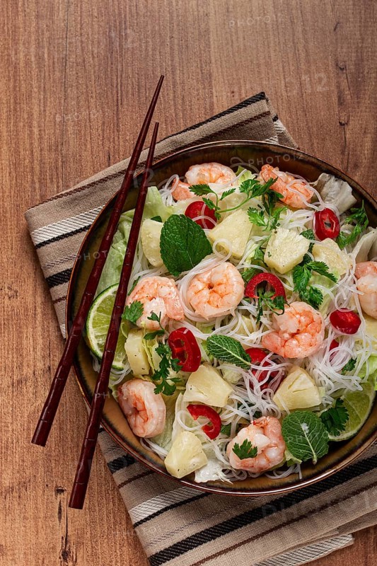 Thai salad with shrimp and rice noodles, pineapple slices, coriander and mint leaves, homemade, no people