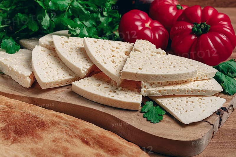 Georgian sliced cheese, on a wooden chopping board, with tomatoes with herbs and lavash, rustic style, Georgian cuisine, no people