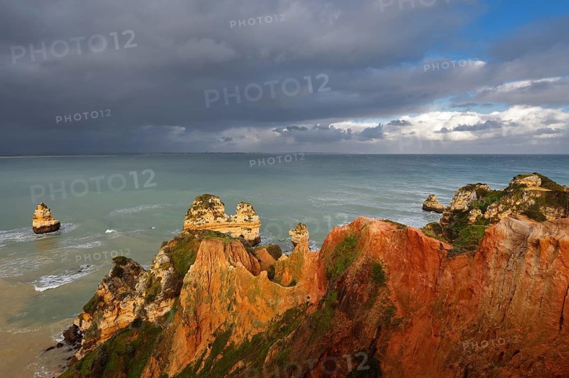 Rocky coast with storm cloud, Praia do Camilo, Lagos, Algarve, Portugal