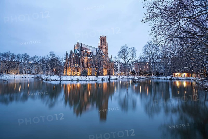 March 18, 2018, winter dusk with snow, illuminated lake and Gothic church Johanneskirche, calm reflections, Feuersee, Stuttgart, Baden-Württemberg, Germany