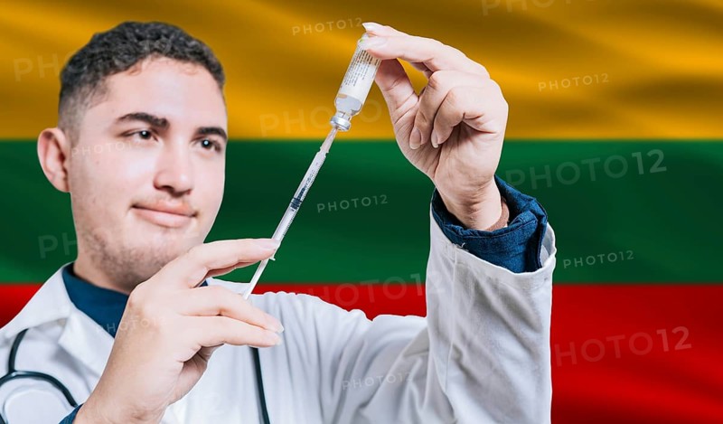 Doctor holding syringe on Lithuania flag background. Medical professional holding syringe with Lithuanian flag in the background