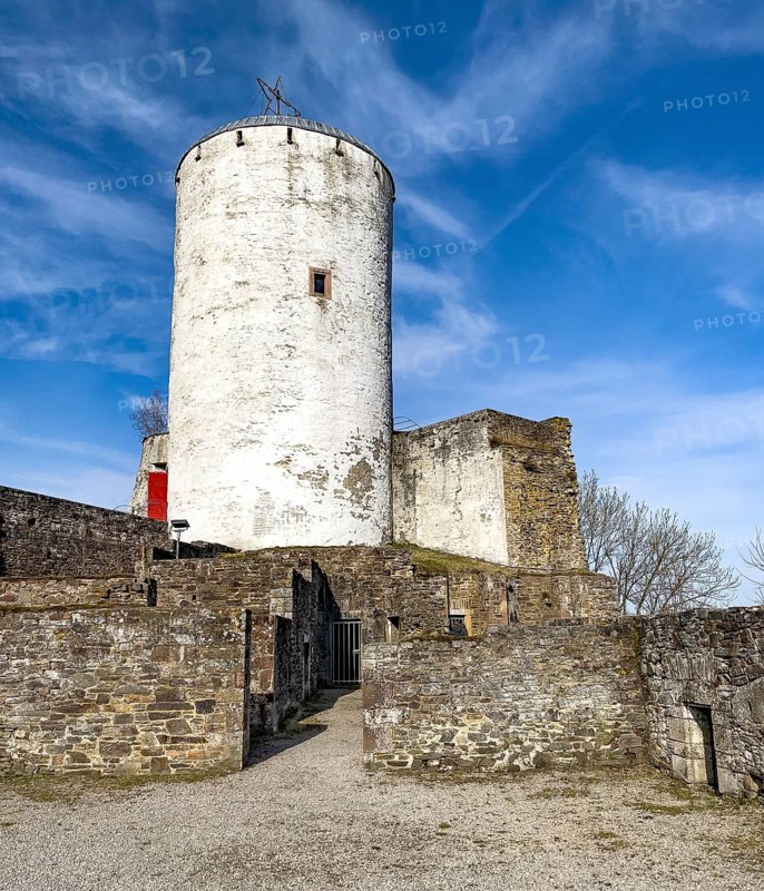 View of castle tower Bergfried made of stone masonry of castle ruins of medieval Höhenburg Reifferscheid Castle Excursion destination in Eifel, preserved foundations and remains of buildings restored in front of it, Reifferscheid, Hellenthal, Euskirchen district, North Rhine-Westphalia, Germany