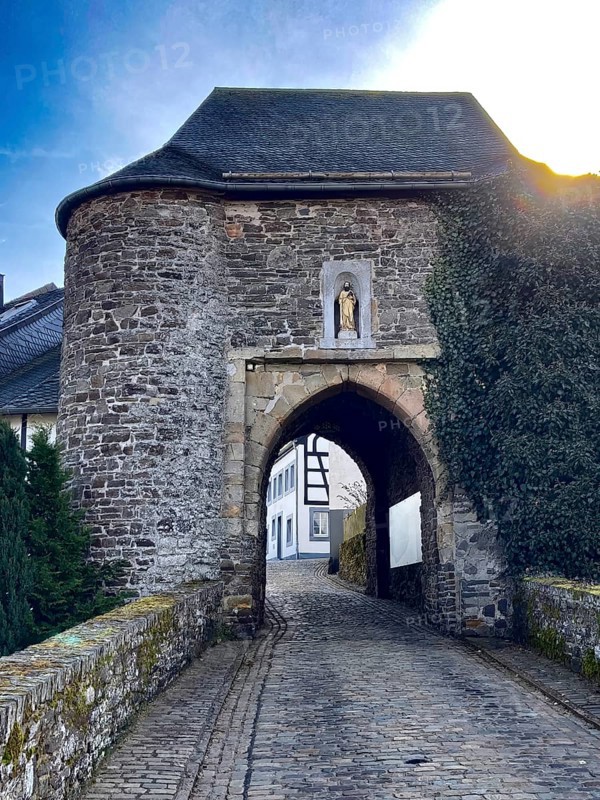 Historic medieval castle gate Matthiastor massive gate building between two fully brick front towers made of quarry stone masonry from the 14th century, access to the castle complex with castle ring from medieval Höhenburg Reifferscheid Castle, historical landmark from the Middle Ages, excursion destination in Eifel, Reifferscheid, Hellenthal, Euskirchen district, North Rhine-Westphalia, Germany