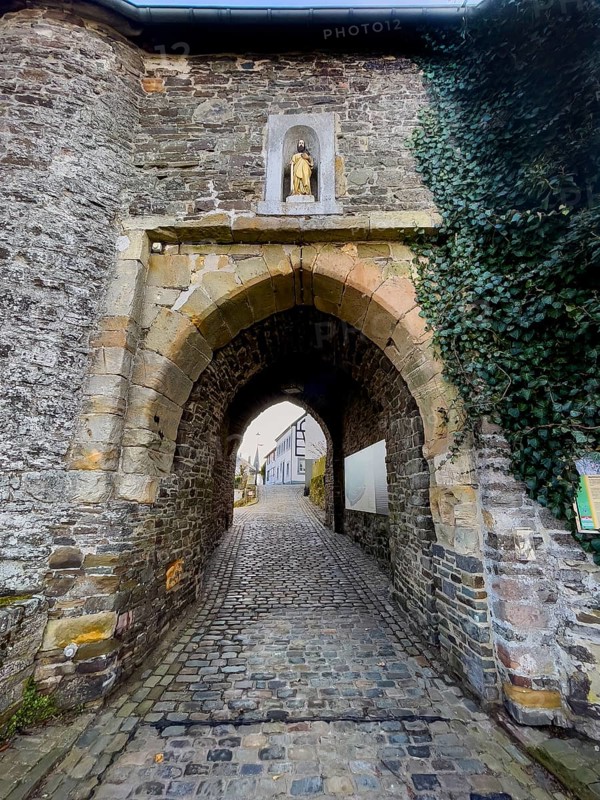 Historic medieval castle gate Matthiastor massive gate building made of quarry stone masonry from the 14th century, access to castle complex with castle bering from medieval Höhenburg Reifferscheid Castle historical landmark from the Middle Ages Excursion destination in Eifel, Reifferscheid, Hellenthal, Euskirchen district, North Rhine-Westphalia, Germany