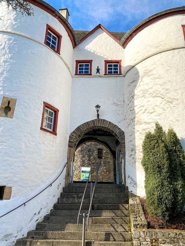 View of stairs to east gate passage into preserved inhabited bailey of medieval hill castle Reifferscheid from Mittellat excursion destination in Eifel, Reifferscheid, Hellenthal, Euskirchen district, North Rhine-Westphalia, Germany