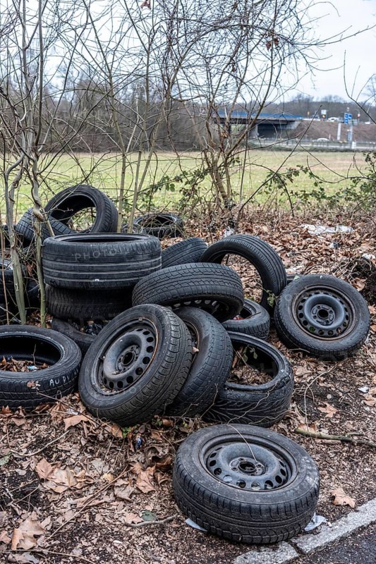 Illegally disposed of car tires and other trash, on a side street in Duisburg-Kaiserberg, North Rhine-Westphalia, Germany