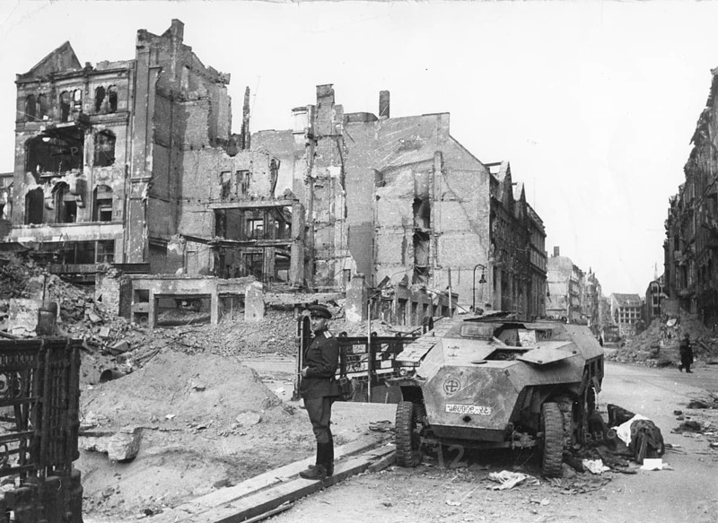 A Soviet soldier stands in front of destroyed residential buildings in Berlin, early May 1945 Germany