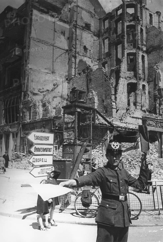 Traffic police officer in front of a destroyed residential building, Berlin June 1945, Germany