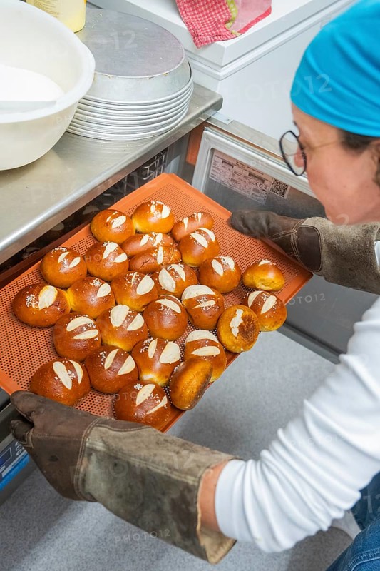 Baker takes freshly baked rolls out of the oven on a baking tray, bake rolls, Haselstaller Hof, Gechingen, Germany