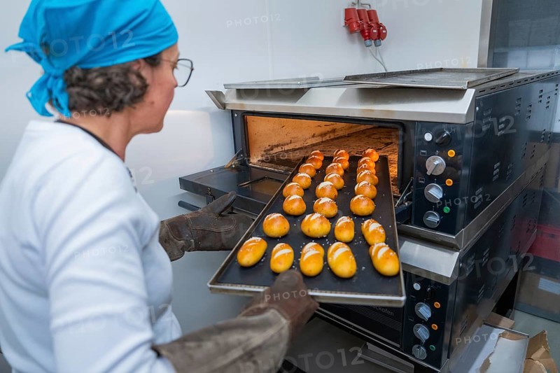 A baker pushes a sheet of golden rolls into the oven, bake rolls, Haselstaller Hof, Gechingen, Germany