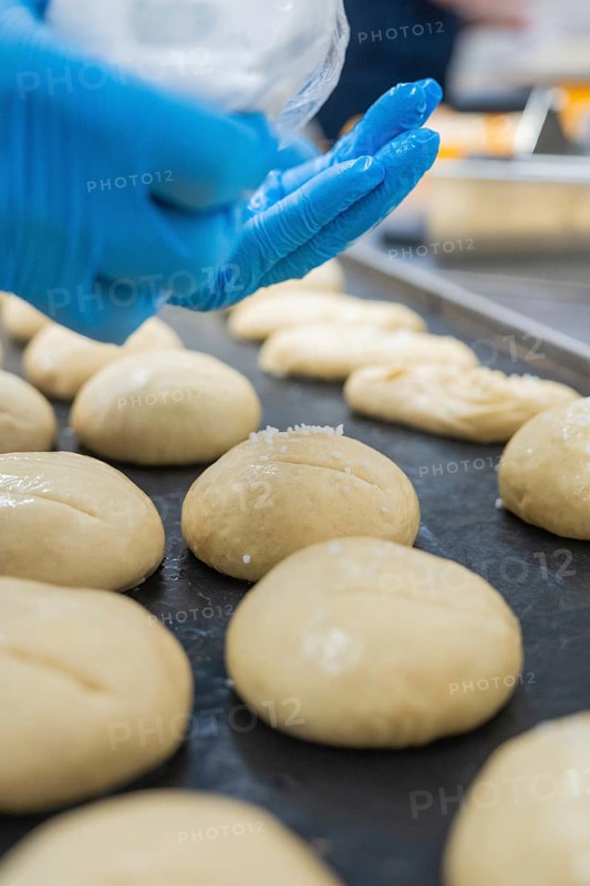 Baker hand with glove spread dough pieces on baking tray, bake rolls, Haselstaller Hof, Gechingen, Germany