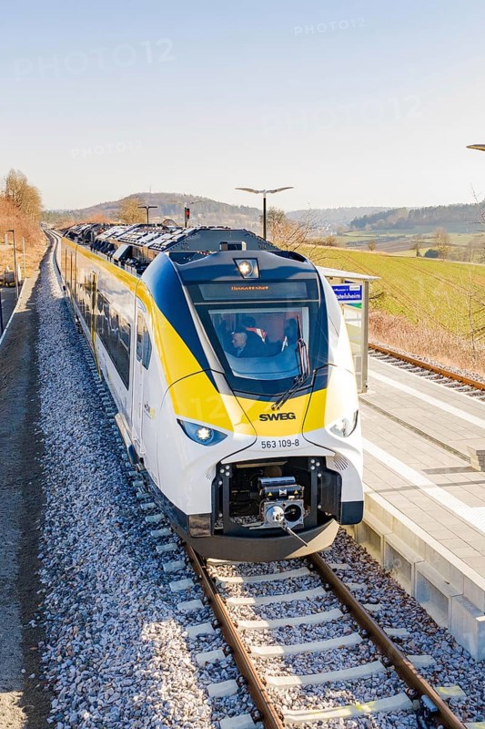 Front view of a modern train at the station, surrounded by hilly landscape, test run on the new Hermann-Hesse railway with Siemens Mireo Plus B trains, Calw, Germany