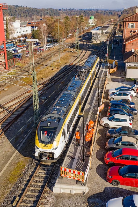 Aerial view of a train station with a passing train and parked cars, test run on the new Hermann-Hesse railway with Siemens Mireo Plus B trains, Calw, Germany