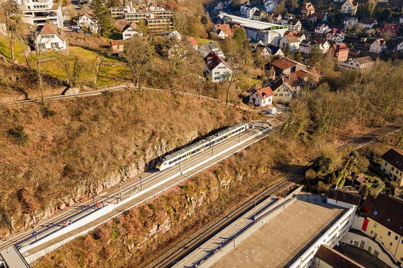 Overview of a train in a village with numerous houses and autumn landscape, test run on the new Hermann-Hesse railway with Siemens Mireo Plus B trains, Calw, Germany