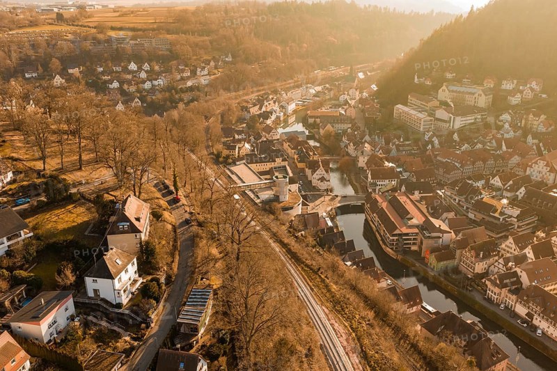 Small river town with train tracks and autumn tree scenery, test trip on the new Hermann-Hesse railway with Siemens Mireo Plus B trains, Calw, Germany