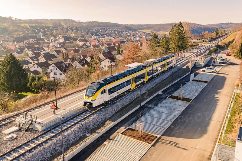 Train at a train station in a rural area surrounded by hills and houses, test ride on the new Hermann-Hesse railway with Siemens Mireo Plus B trains, Calw, Germany