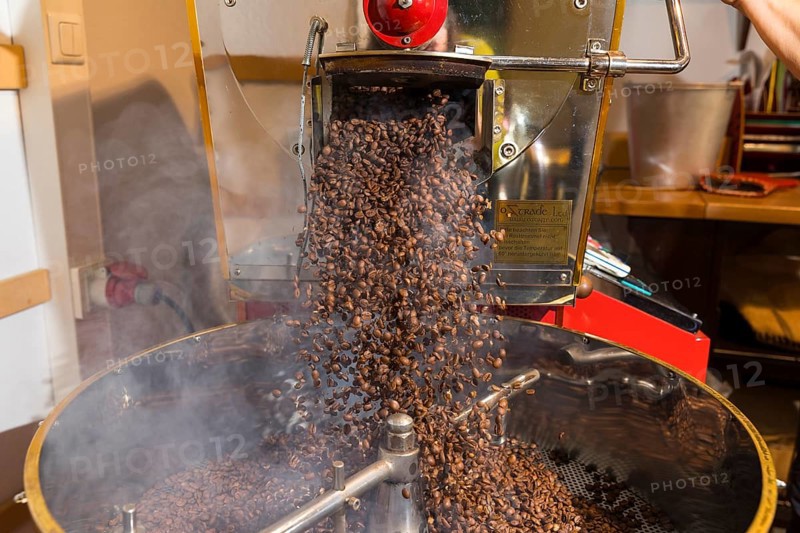 Coffee is roasted by hand in a small drum roasting machine with a lot of experience, where the finished hot coffee beans are just being poured out to cool in a sieve, Kaffeerösterei Müller, Wildenhain, Großenhain, Saxony, Germany