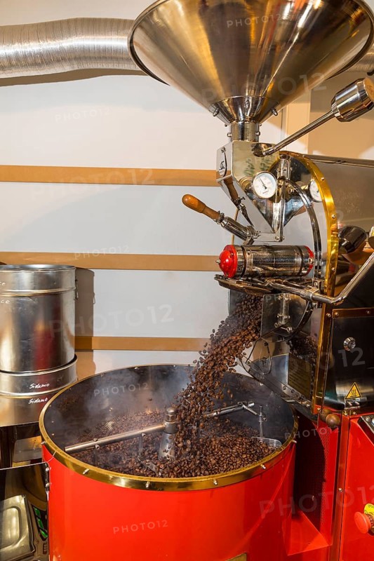 Coffee is roasted by hand in a small drum roasting machine with a lot of experience, where the finished hot coffee beans are just being poured out to cool in a sieve, Kaffeerösterei Müller, Wildenhain, Großenhain, Saxony, Germany