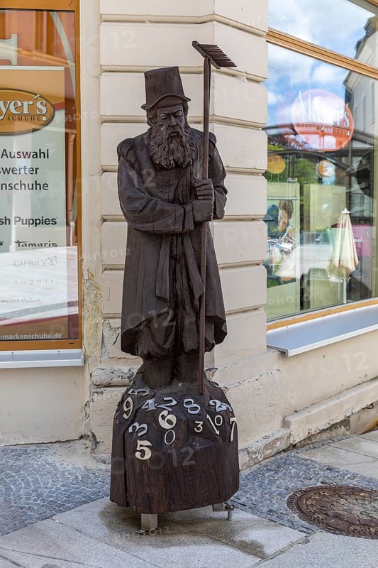 Wooden sculpture of Adam Ries as an arithmetic with numbers, signpost to the Adam Ries House and memorial in Annaberg, Annaberg-Buchholz, Erzgebirge, Saxony, Germany