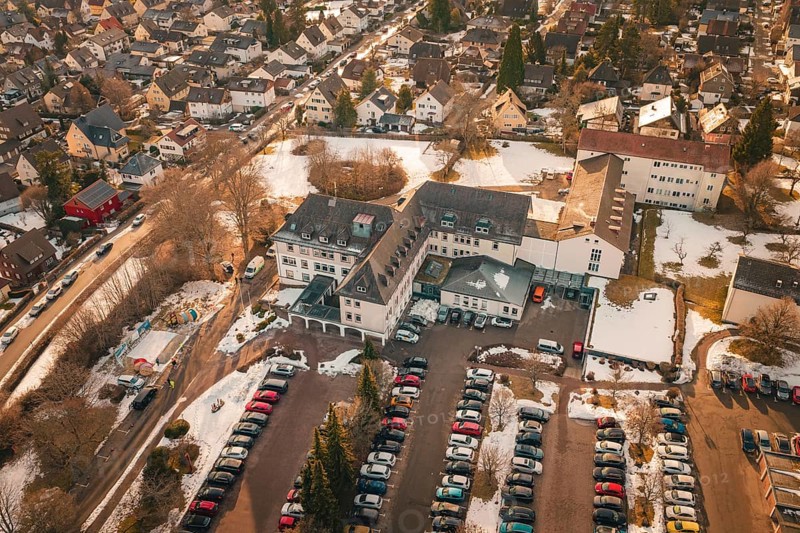 View of a large building complex with parking spaces and surrounding residential area in winter, District Office, Freudenstadt, Black Forest, Germany