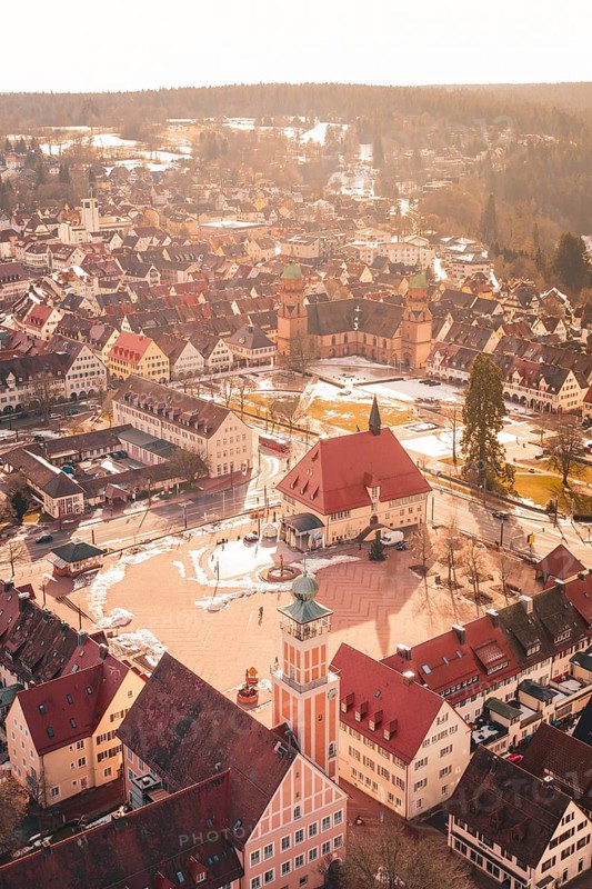 City view with church tower and historic buildings covered by light snow at sunset, Freudenstadt, Black Forest, Germany