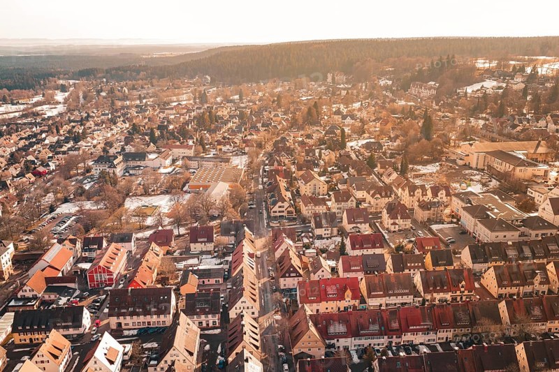 Panoramic view of a city in sunlight with numerous roofs and adjacent forest, Freudenstadt, Black Forest, Germany