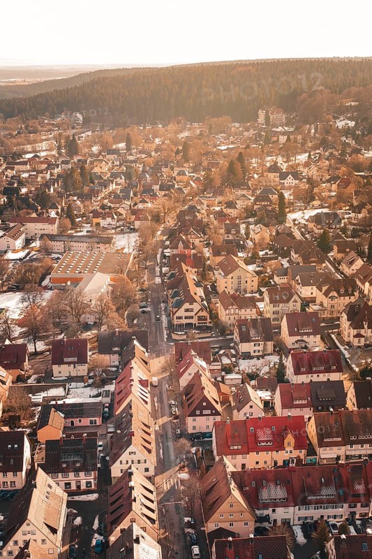 Aerial view of a city with red roofs surrounded by forests and light snow, Freudenstadt, Black Forest, Germany