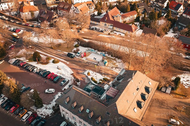 Bird's eye view of a snowy road with buildings and parked cars on a wintry day, Freudenstadt, Black Forest, Germany