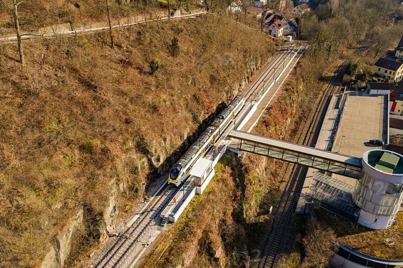 Overview of train journey through hilly vegetation and bridge in urban surroundings, test run on the new Hermann-Hesse railway with Siemens Mireo Plus B trains, Calw, Germany