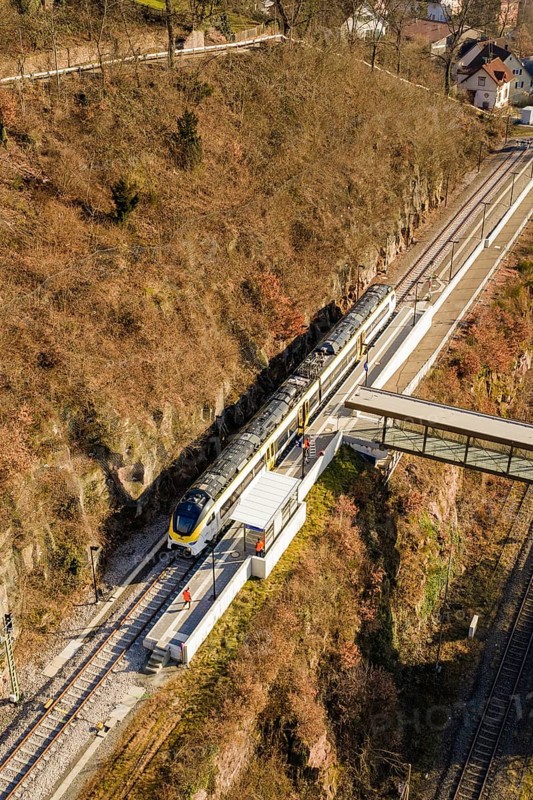 Vertical view of a train station with bridge surrounded by autumn landscape, test run on the new Hermann-Hesse railway with Siemens Mireo Plus B trains, Calw, Germany