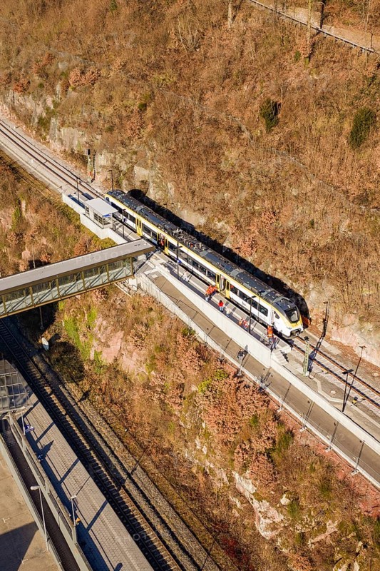 Train travels through hilly landscape over bridge surrounded by vegetation and tracks, test run on the new Hermann Hesse railway with Siemens Mireo Plus B trains, Calw, Germany