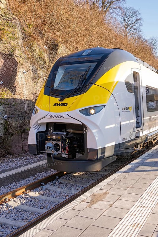 Yellow-black train at a small train station in a mountainous landscape, test run on the new Hermann-Hesse railway with Siemens Mireo Plus B trains, Calw, Germany