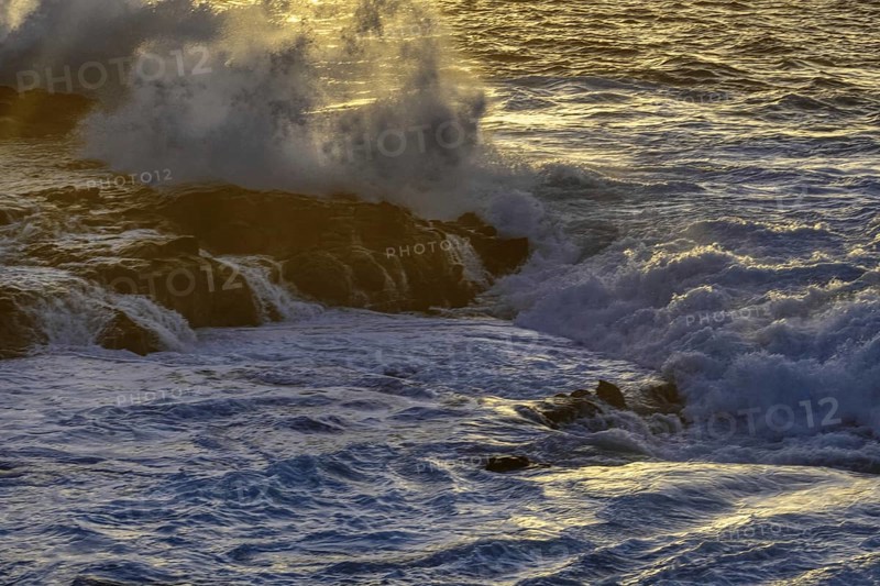 Thundering waves hit a rocky coast illuminated by soft sunlight during sunset, Playa Blanca/Yaiza Lanzarote