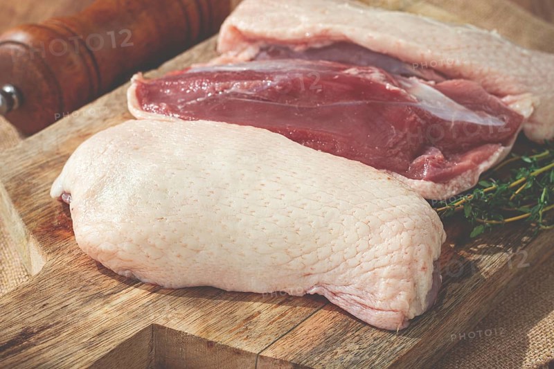 Fresh raw duck breast, on a wooden chopping board, top view, no people