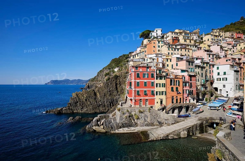 Colourful houses under blue sky, view of the fishing village of Riomaggiore, port, Cinque Terre, La Spezia province, Liguria, Italy