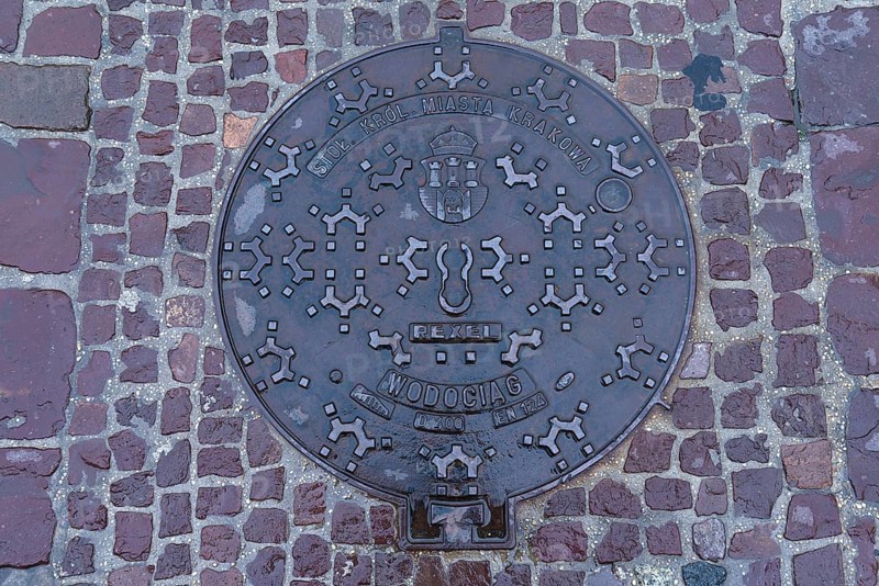 Manhole cover with the coat of arms of the city of Krakow, Krakow, Poland