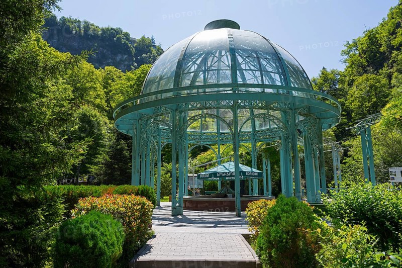 An elegant glass and metal pavilion in a green, sunny landscape surrounded by trees, pavilion with mineral water spring, Borjomi, Borjomi, Borjomi resort, Borjomi, Samtskhe-Javakheti region, Samtskhe-Javakheti, Lesser Caucasus, Georgia