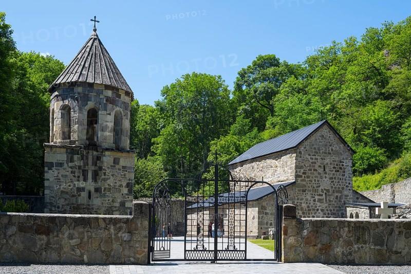 Stone church in a forest under a blue sky with an entrance gate, Chitakhevi Church of St. George, The Green Monastery, Mtsvane Monastery, Samtskhe-Javakheti Region, Samtskhe-Javakheti, Georgia