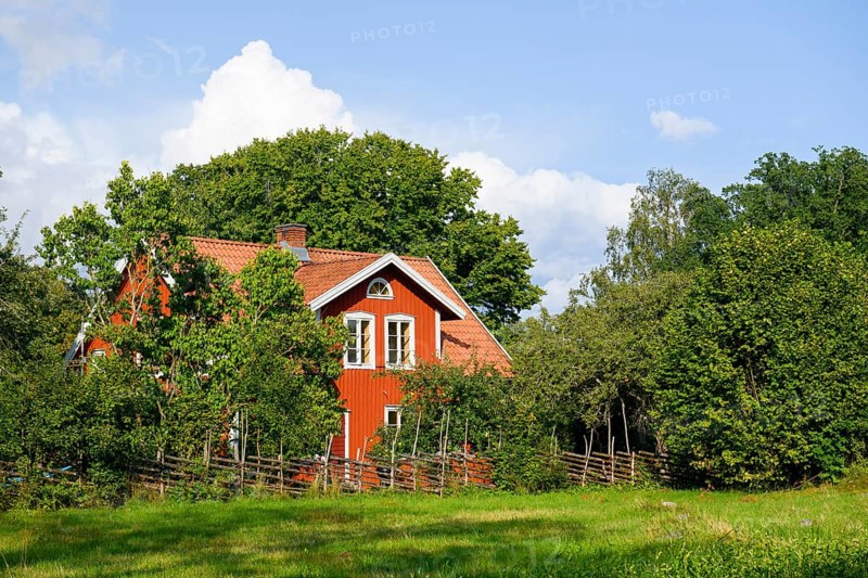 Charming red house with white windows, surrounded by trees and a wooden fence at the birthplace of botanist and founder of the binary nomenclature Carl von Linné, Linnés Råshult, Älmhult, Kronobergs län, Småland, Sweden